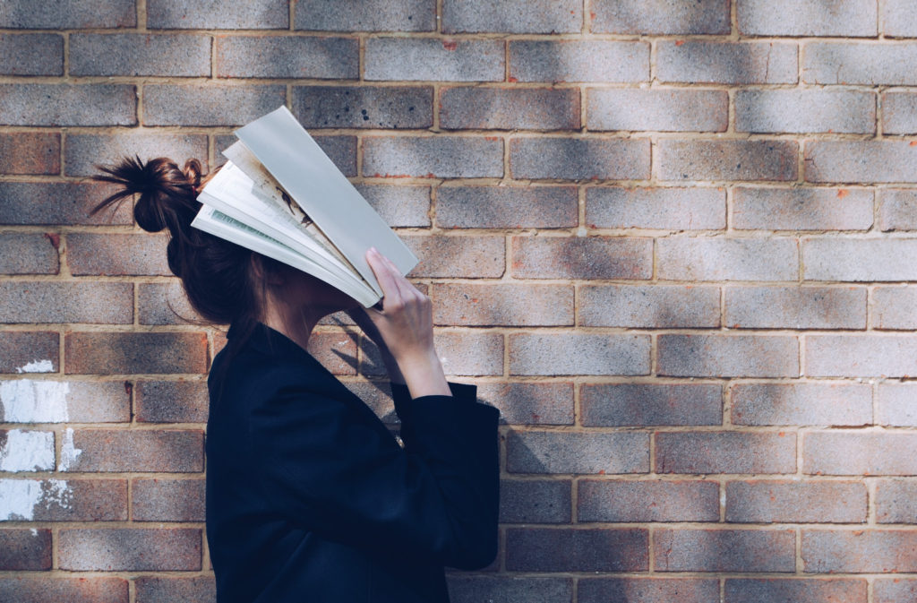 stressed woman with book to her head